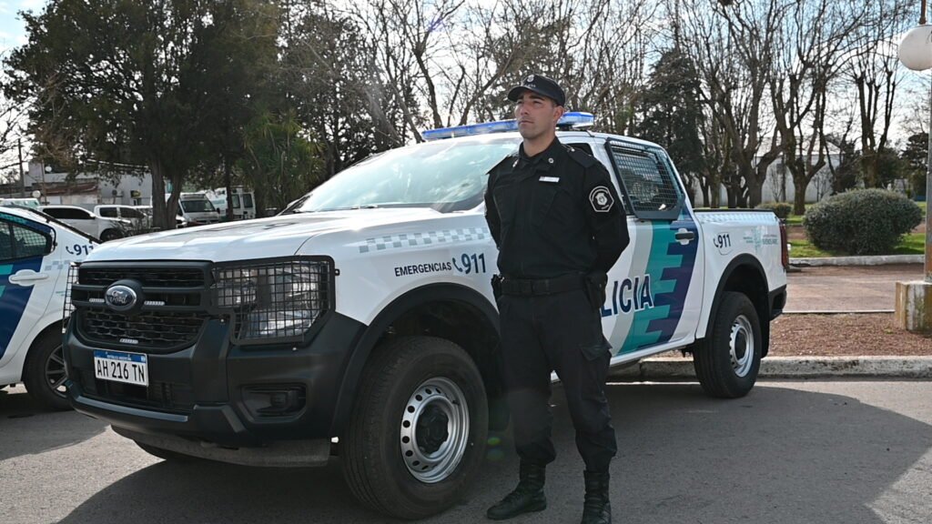 Efectivo de la Policía de la Provincia de Buenos Aires junto a un móvil policial en San Martín